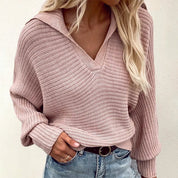 Maglione rosa a maglia grossa con scollo a V, indossato da donna con jeans. Stile casual, moda autunnale, abbigliamento femminile trendy.