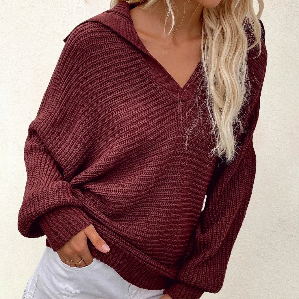 Maglione donna in maglia a coste bordeaux, maniche lunghe, scollo a V, abbinato a pantaloni bianchi. Look casual autunnale.