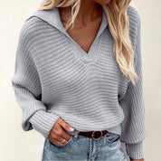 Maglione donna grigio in maglia a coste, scollo a V, maniche lunghe, abbinato a jeans. Moda autunno inverno, stile casual chic.