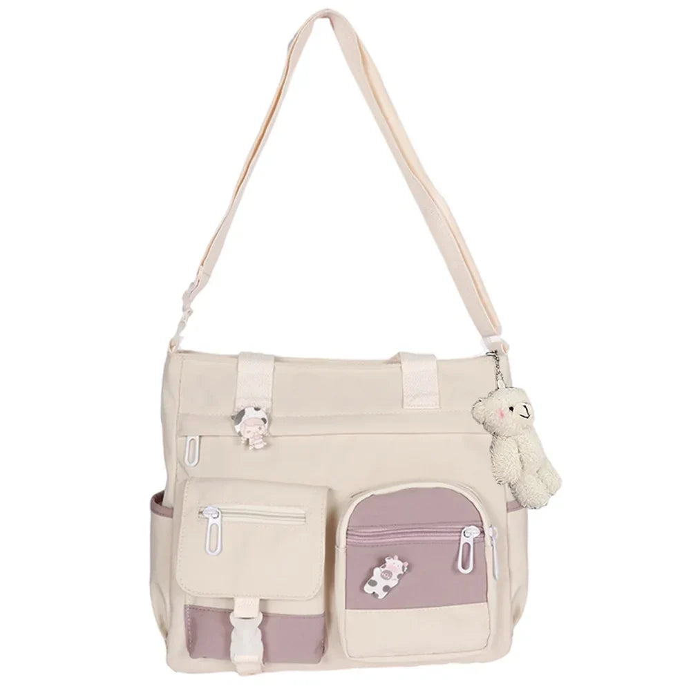Borsa a tracolla beige con tasche multiple e ciondolo orsetto, design casual, ideale per scuola o lavoro. Accessorio moda donna pratico e trendy.