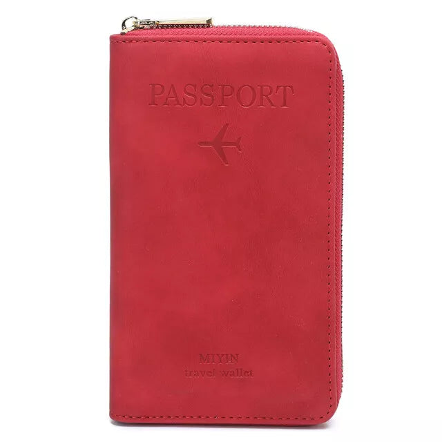 Portafoglio da viaggio rosso in pelle con cerniera, design per passaporto, logo aereo inciso, ideale per viaggiatori. Accessorio elegante e funzionale.