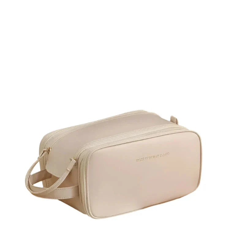 Borsa da toilette beige in pelle sintetica, design elegante e minimalista, doppia cerniera, ideale per viaggi e organizzazione accessori bagno.