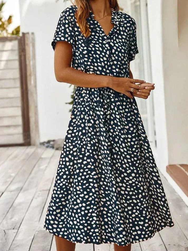 Abito estivo donna a pois bianchi su sfondo nero, maniche corte, lunghezza media, perfetto per look casual e moda estiva.
