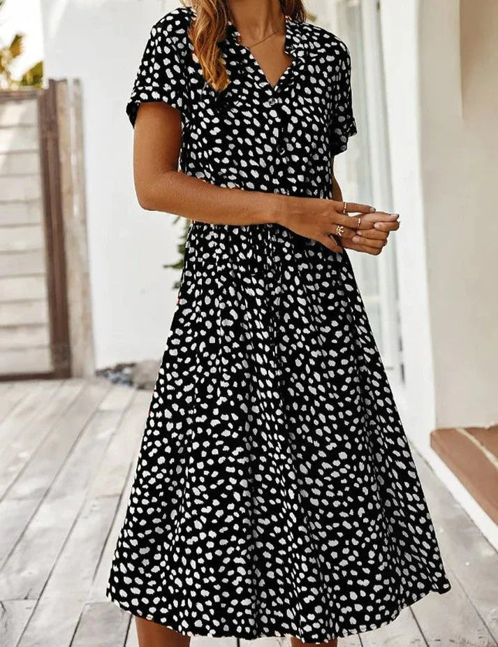 Abito estivo donna nero a pois bianchi, maniche corte, scollo a V, lunghezza al ginocchio, perfetto per moda casual e look estivo elegante.