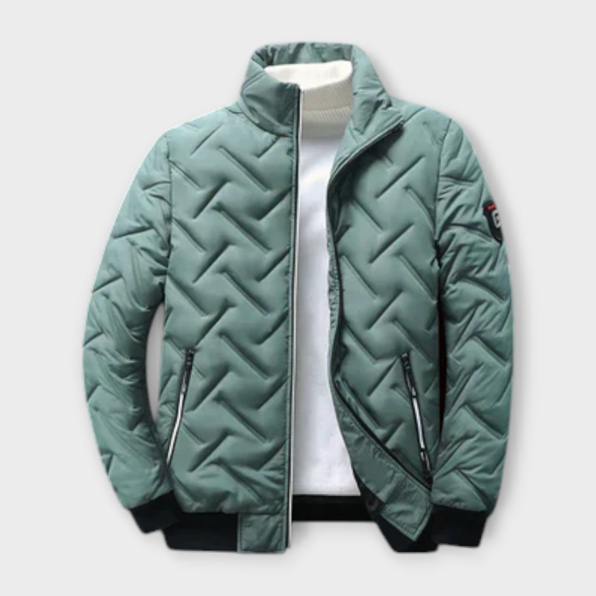 Giacca trapuntata verde uomo, collo alto, chiusura zip, tasche laterali, polsini e orlo a costine, ideale per l'inverno. Moda casual elegante.