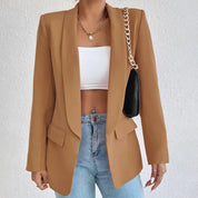 Giacca blazer donna marrone elegante, abbinata a top bianco e jeans. Accessori: collana oro e borsa nera a tracolla. Moda casual chic.