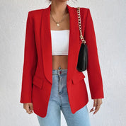 Giacca rossa elegante da donna, abbinata a top bianco e jeans. Accessori: collana dorata e borsa nera a tracolla. Moda femminile casual chic.