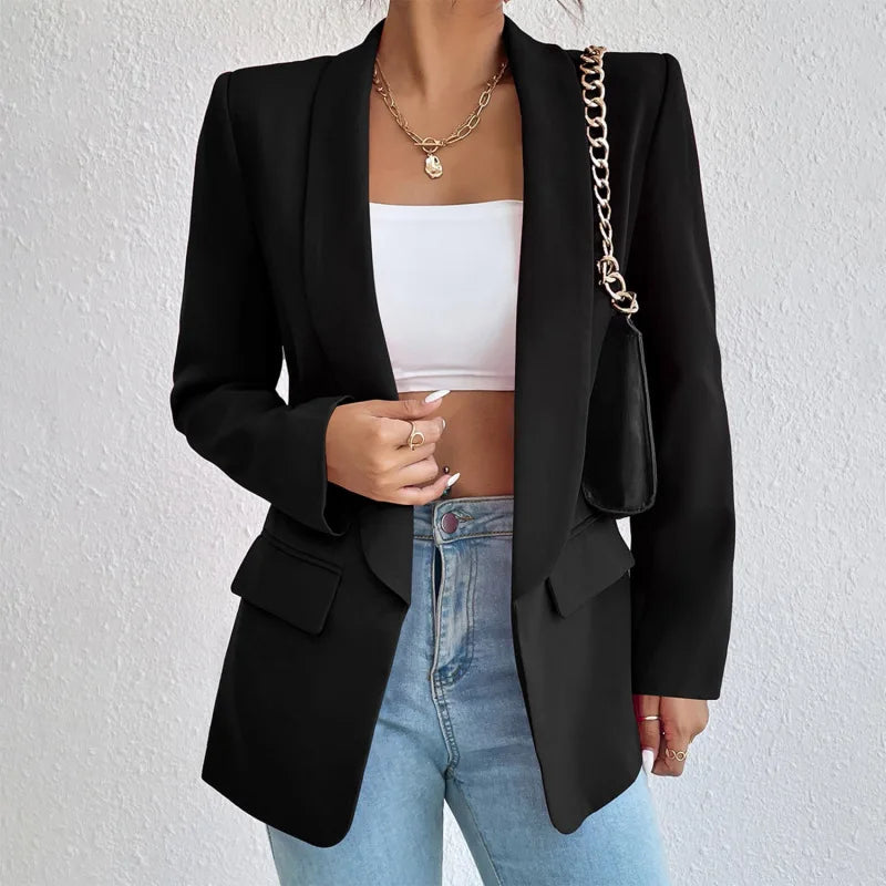 Giacca blazer nero elegante donna, abbinata a top bianco e jeans, con borsa a catena. Moda femminile, abbigliamento casual chic.