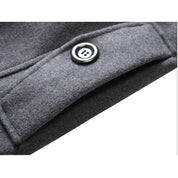 Cappotto in lana grigia con bottone nero, dettaglio tasca. Elegante e caldo, ideale per l'inverno. Moda uomo, abbigliamento invernale.
