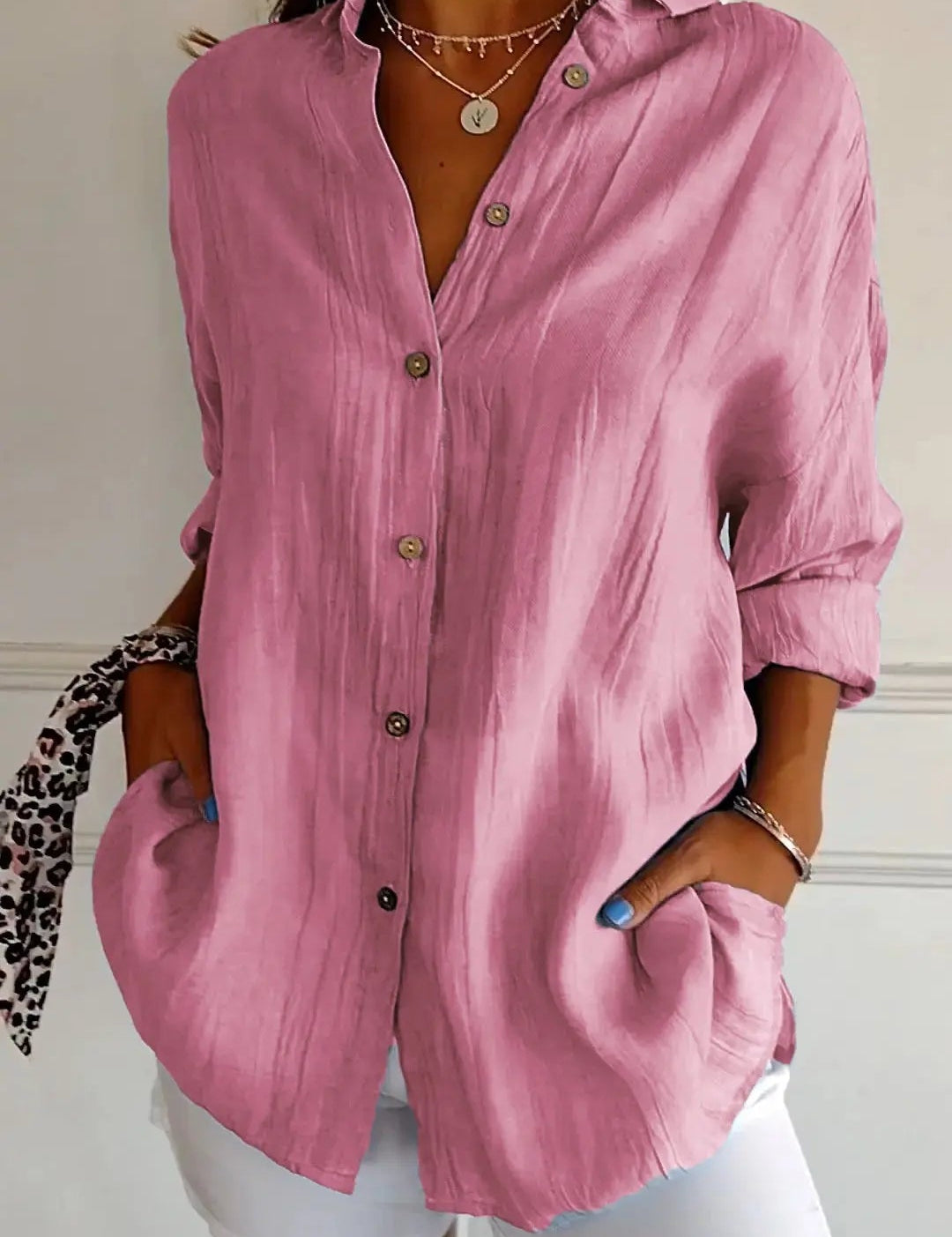 Camicia donna rosa a maniche lunghe, bottoni frontali, tessuto leggero, abbinata a pantaloni bianchi. Stile casual elegante, moda femminile.