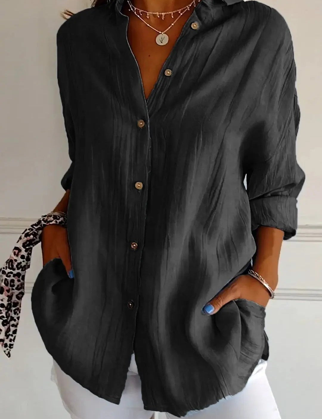 Camicia nera da donna con bottoni, maniche lunghe, tasche, abbinata a pantaloni bianchi. Stile casual elegante, perfetta per moda autunnale.