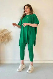 Donna con abito verde a coste, maglia oversize e pantaloni abbinati, scarpe da ginnastica bianche. Moda casual, abbigliamento donna elegante.