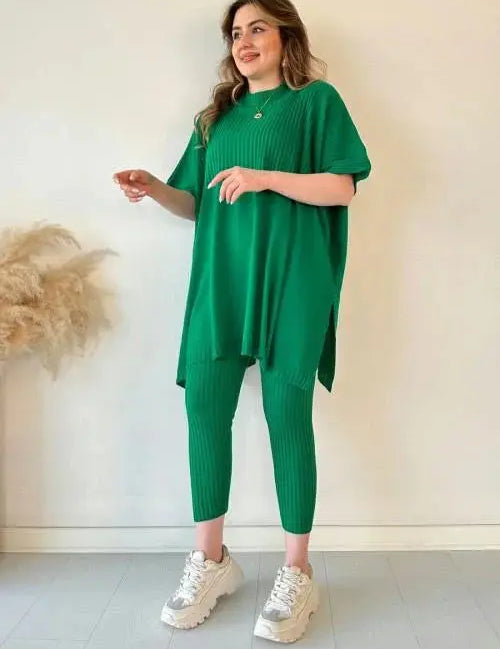 Donna con abito verde a coste, maglia oversize e pantaloni abbinati, scarpe da ginnastica bianche. Moda casual, abbigliamento donna elegante.