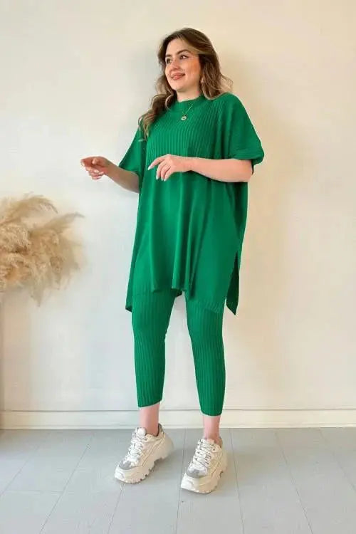 Donna con abito verde a coste, maglia oversize e pantaloni abbinati, scarpe da ginnastica bianche. Moda casual, abbigliamento donna elegante.