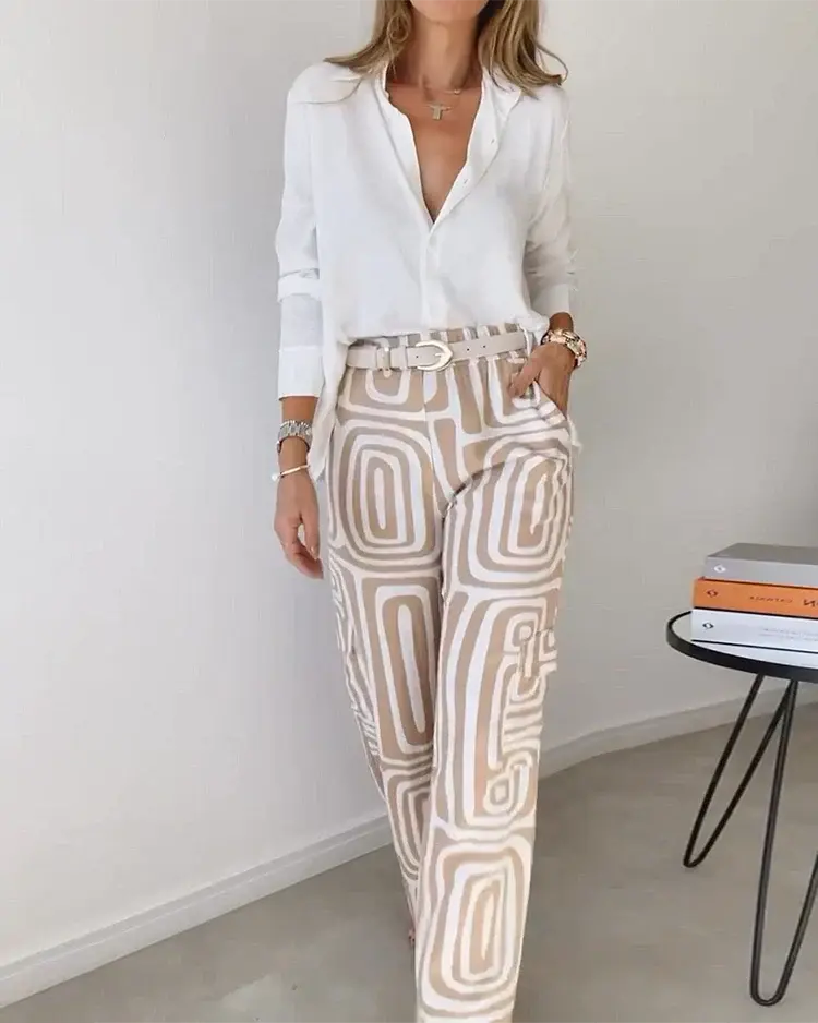 Camicia bianca elegante e pantaloni a fantasia geometrica beige, donna in posa. Moda femminile, abbigliamento casual chic, tendenze 2023.