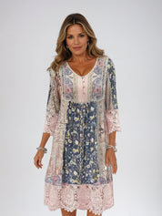 Abito donna boho chic floreale, maniche a 3/4, scollo a V, dettagli in pizzo, colori pastello. Moda femminile elegante e casual.
