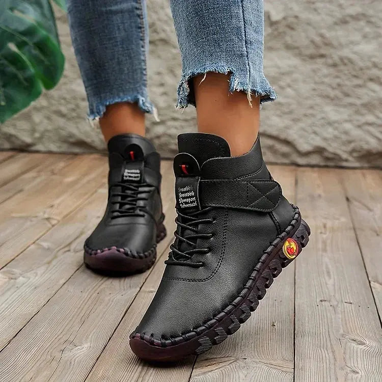 Scarpe da donna in pelle nera, stivaletti casual con suola antiscivolo, indossati con jeans. Design moderno e confortevole per l'autunno.