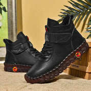 Stivaletti neri in pelle con suola marrone antiscivolo, design casual, chiusura a lacci, sfondo tropicale. Scarpe uomo moda autunno inverno.