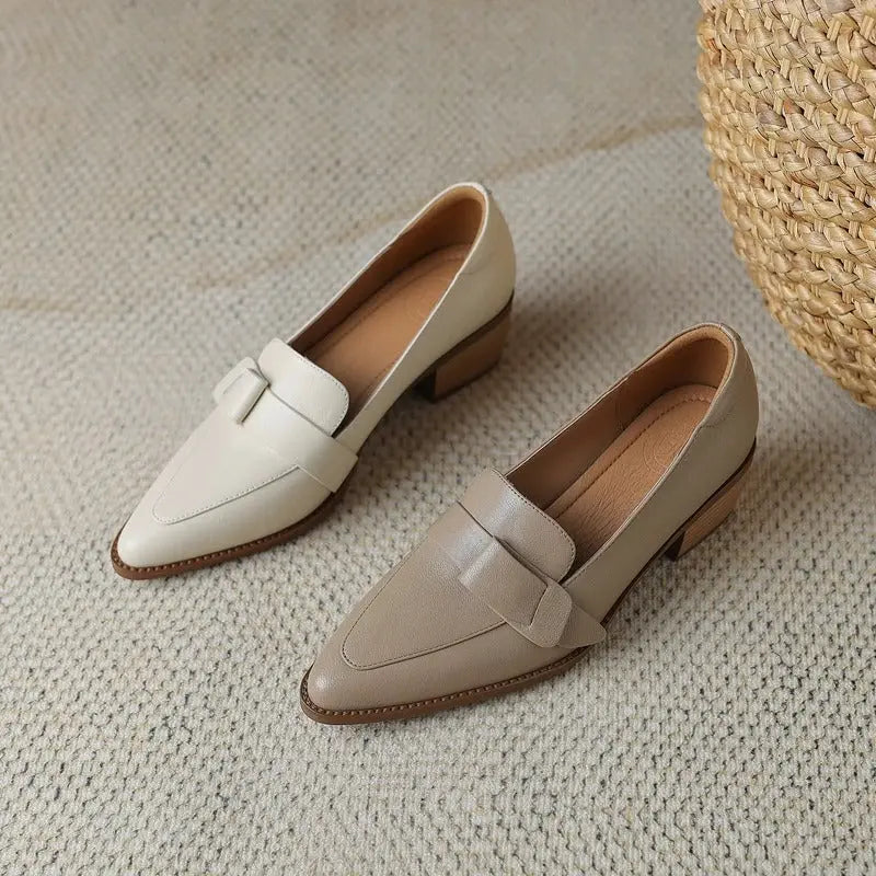 Scarpe mocassini donna in pelle beige e marrone chiaro su tappeto, design elegante con tacco basso. Calzature moda autunno, stile casual chic.