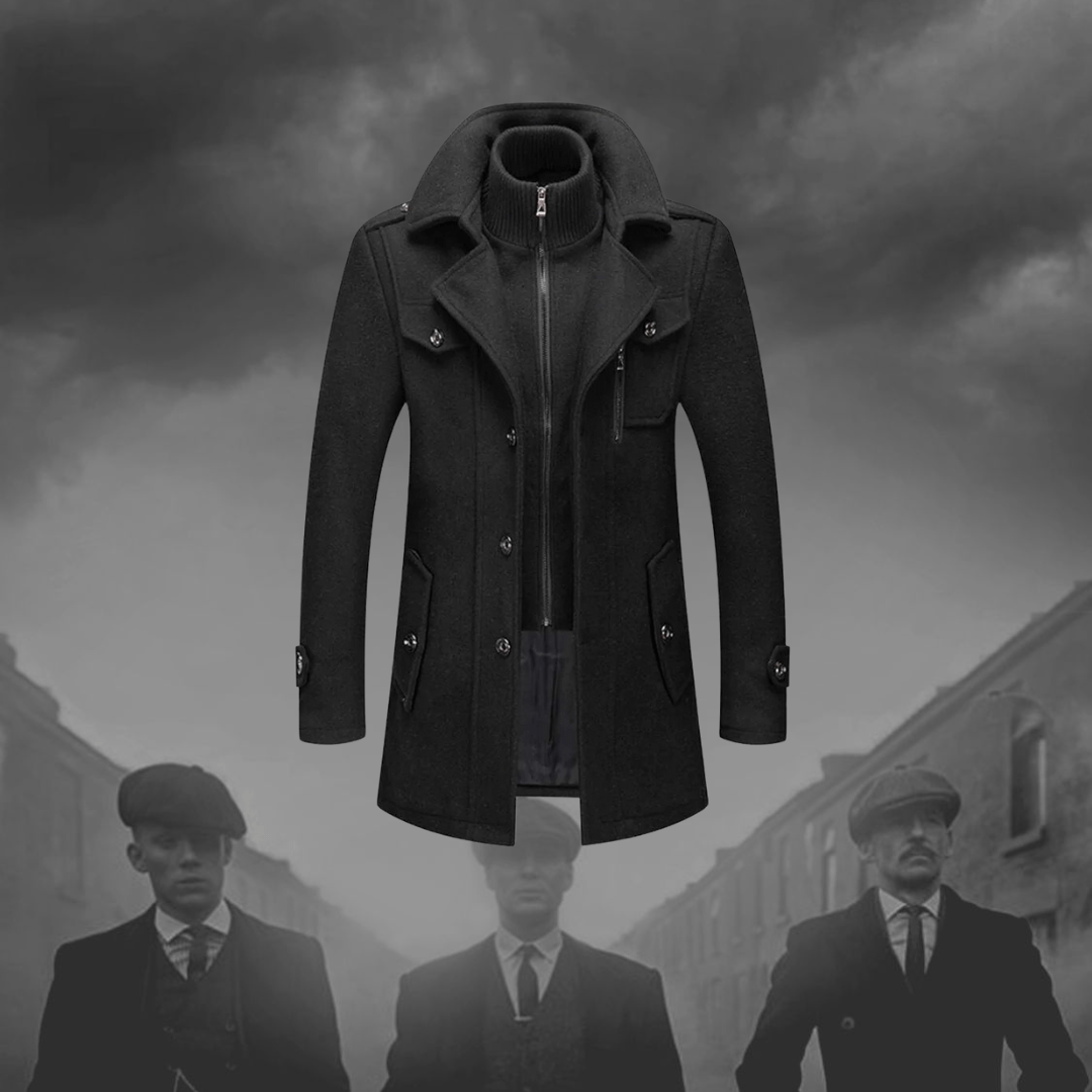 Cappotto uomo elegante nero, stile vintage, con colletto alto e bottoni, ispirato alla moda retrò. Sfondo grigio con figure sfocate.