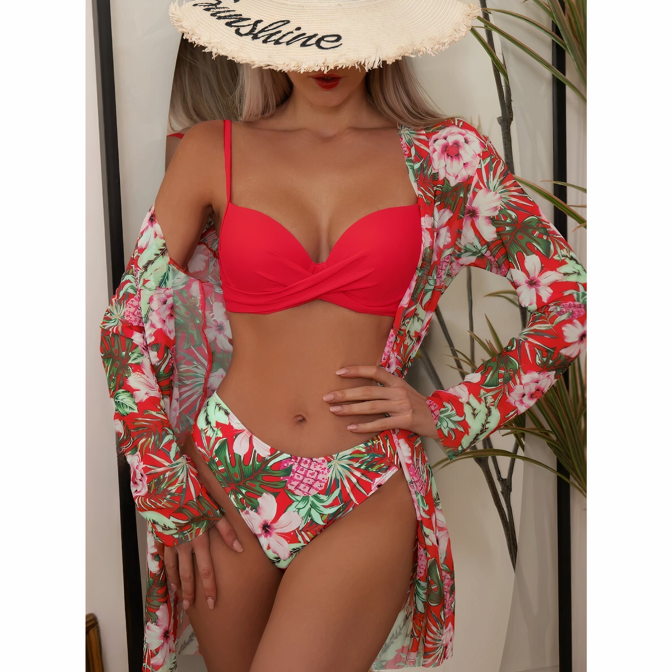 Costume da bagno donna rosso con stampa floreale, abbinato a copricostume coordinato. Cappello di paglia con scritta. Moda mare estiva.