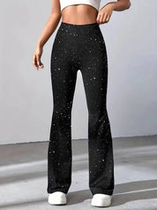 Pantaloni a zampa neri con stampa a stelle bianche, indossati da una modella. Moda donna, abbigliamento casual, stile trendy e moderno.