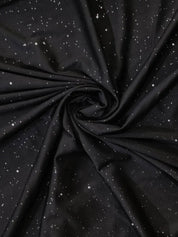 Tessuto nero con motivo a stelle bianche, ideale per abbigliamento e decorazioni. Materiale morbido e resistente, perfetto per progetti creativi.