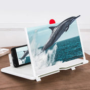 Amplificatore schermo smartphone bianco su tavolo in legno, ingrandisce immagine di delfino che salta dall'acqua. Accessorio pratico per visione video.