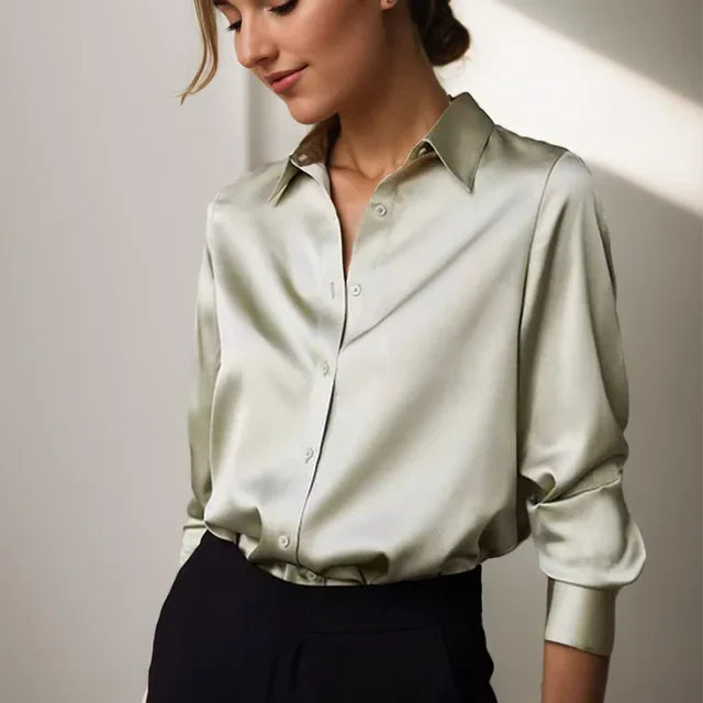Camicia donna in seta verde chiaro, maniche lunghe, colletto classico, abbinata a pantaloni neri eleganti. Moda femminile, abbigliamento formale.