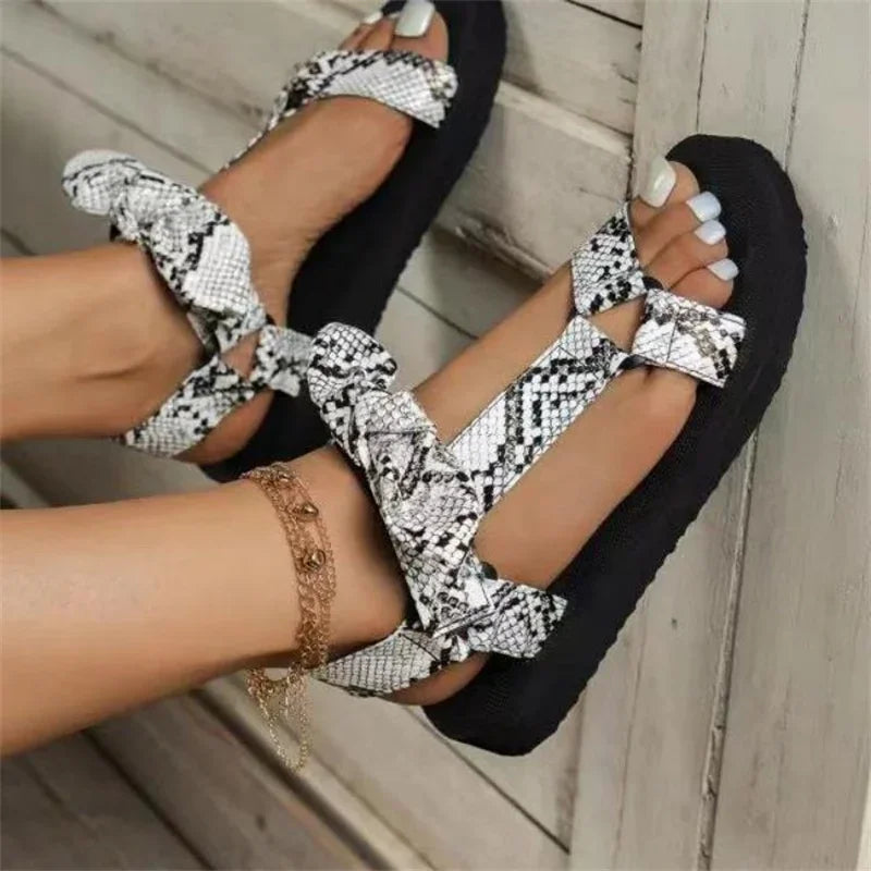 Sandali donna con stampa serpente, suola nera, cinturini regolabili, stile casual estivo, perfetti per look alla moda e comfort quotidiano.
