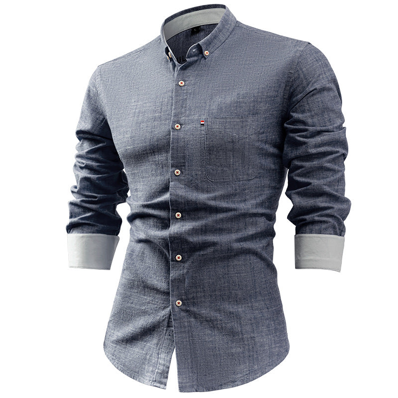 Camicia uomo in denim blu, maniche lunghe, colletto button-down, taschino frontale, bottoni bianchi. Elegante e casual, moda maschile.