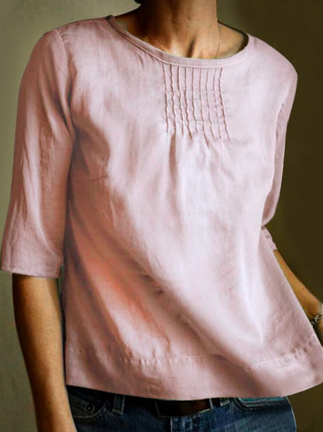 Maglietta rosa in lino da donna con maniche a tre quarti, scollo rotondo e dettagli a pieghe sul petto. Elegante e casual, perfetta per ogni occasione.