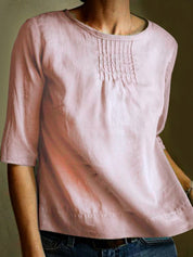 Blusa donna rosa in lino, maniche a tre quarti, scollo rotondo, dettagli pieghettati sul petto. Elegante e casual, perfetta per ogni occasione.