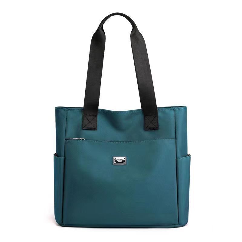 Borsa tote donna in pelle blu con manici neri, tasche laterali e chiusura con zip. Elegante e spaziosa, ideale per l'uso quotidiano.
