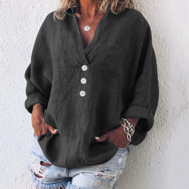Camicia donna nera oversize con bottoni bianchi, maniche lunghe arrotolate, abbinata a jeans strappati. Stile casual, moda femminile.