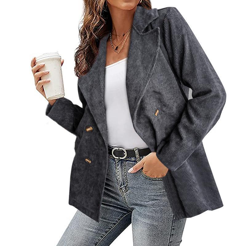 Donna con blazer grigio a righe, top bianco e jeans, tiene una bevanda. Moda casual elegante, abbigliamento autunnale, stile urbano.