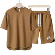 Set coordinato uomo marrone, t-shirt e pantaloncini casual in cotone, design minimalista, ideale per l'estate. Abbigliamento maschile comodo e alla moda.