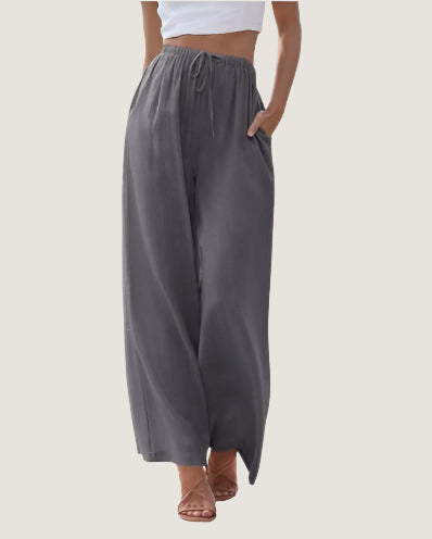 Pantaloni palazzo grigi da donna, vita alta con coulisse, tasche laterali, tessuto leggero. Ideali per look casual e moda estiva.