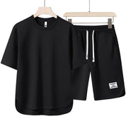 Set coordinato uomo nero, t-shirt e pantaloncini sportivi, cotone, casual, estivo, con coulisse, ideale per palestra e tempo libero.