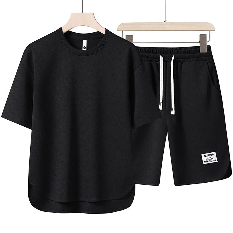 Set coordinato uomo nero, t-shirt e pantaloncini sportivi, cotone, casual, estivo, con coulisse, ideale per palestra e tempo libero.