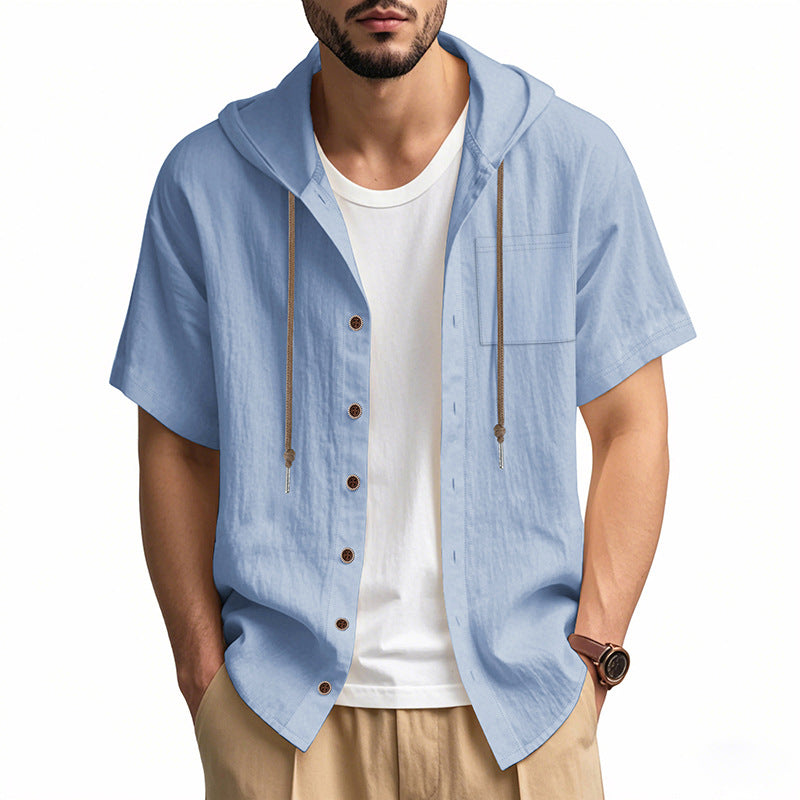 Camicia uomo azzurra con cappuccio, maniche corte, bottoni in legno, indossata sopra t-shirt bianca. Stile casual estivo, moda maschile.