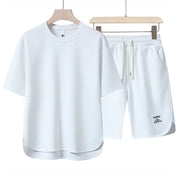 Set abbigliamento sportivo bianco, maglietta e pantaloncini in cotone, design minimalista, ideale per palestra e attività all'aperto.