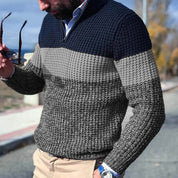 Maglione uomo a righe blu e grigie, lavorato a maglia, con zip, indossato con pantaloni beige. Stile casual autunnale.