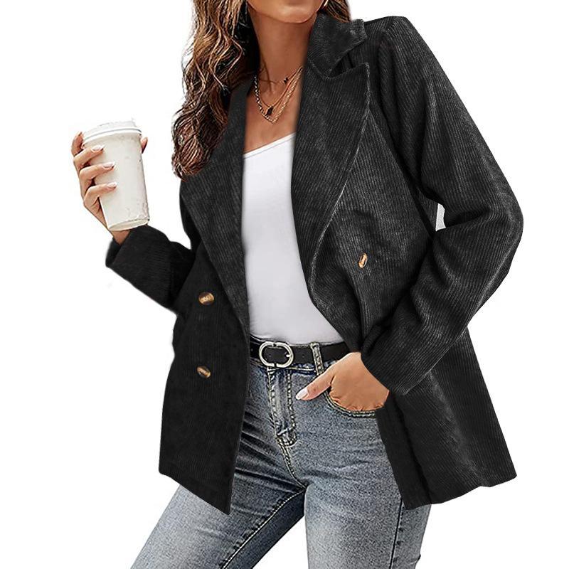 Giacca donna elegante nera a doppio petto, abbinata a jeans e top bianco. Moda autunnale, stile casual chic. Donna con caffè in mano.