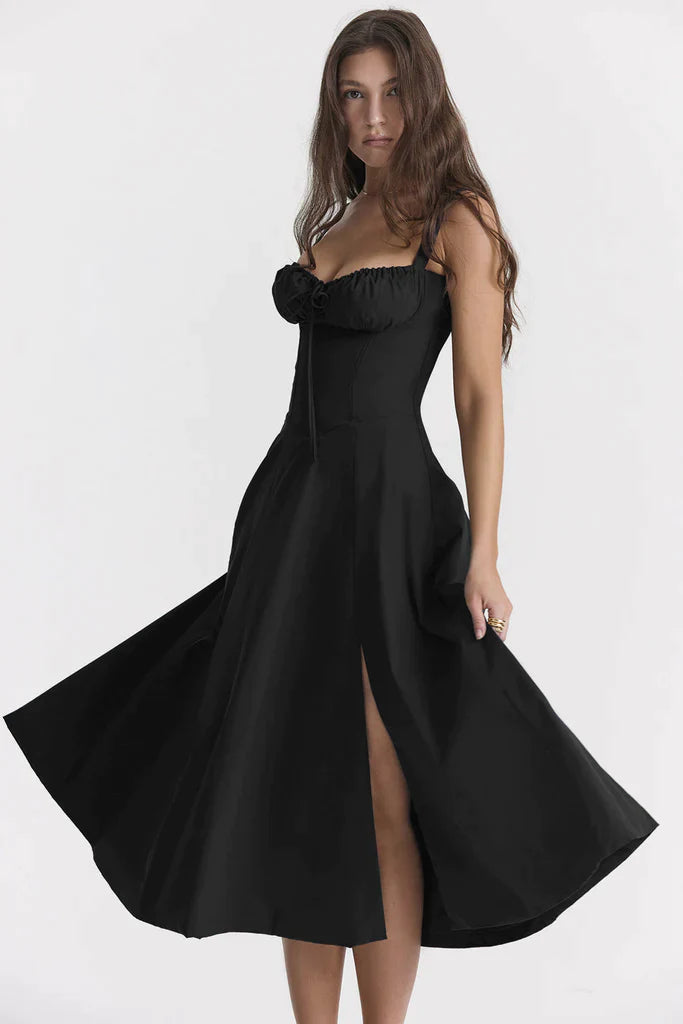 Abito nero elegante con spacco, scollatura arricciata e spalline sottili, indossato da modella. Perfetto per eventi serali e cerimonie.