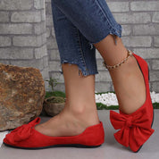 Scarpe ballerine rosse con fiocco, indossate con jeans strappati. Eleganti e casual, perfette per moda donna e abbigliamento estivo.