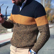 Maglione uomo a righe blu, arancione e marrone, lavorato a maglia, con zip, indossato all'aperto. Stile casual autunnale, moda maschile.