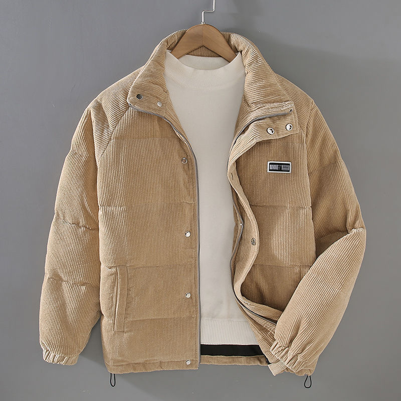 Giacca invernale beige in velluto a coste, imbottita, con colletto alto e chiusura a bottoni, appesa su gruccia. Moda uomo, abbigliamento caldo.
