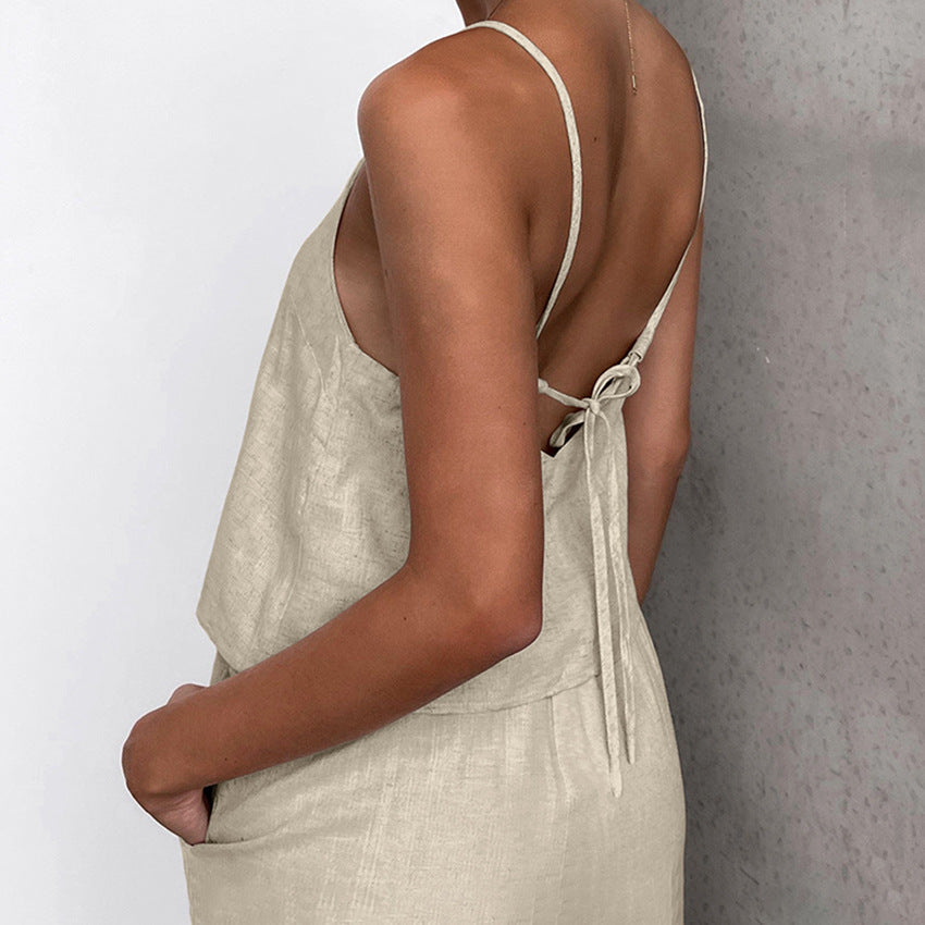 Donna in abito estivo beige con spalline sottili e schiena scoperta, tessuto leggero, moda casual elegante, perfetto per giornate calde.