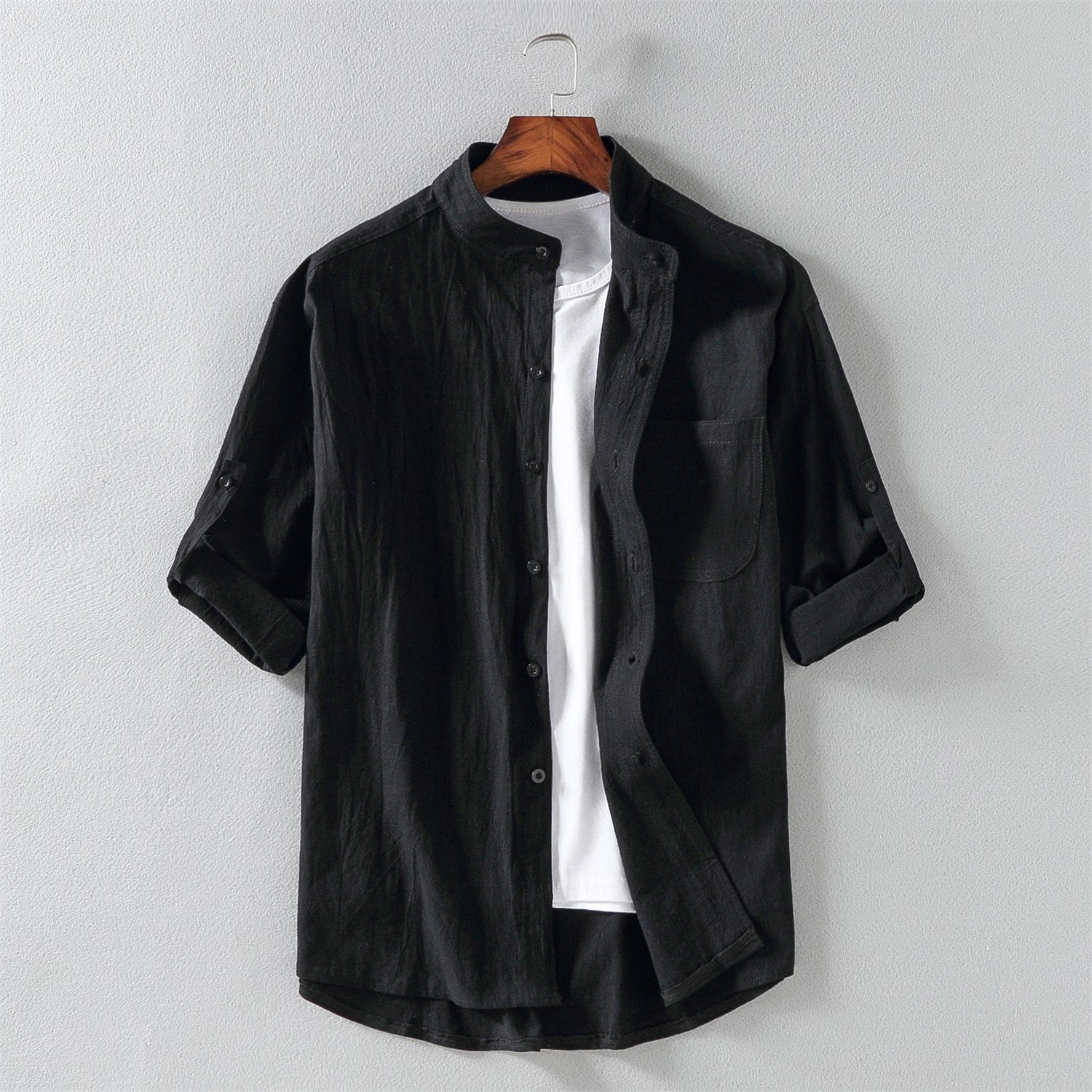 Camicia nera da uomo in cotone, maniche lunghe arrotolate, colletto alla coreana, abbinata a t-shirt bianca. Elegante e casual.